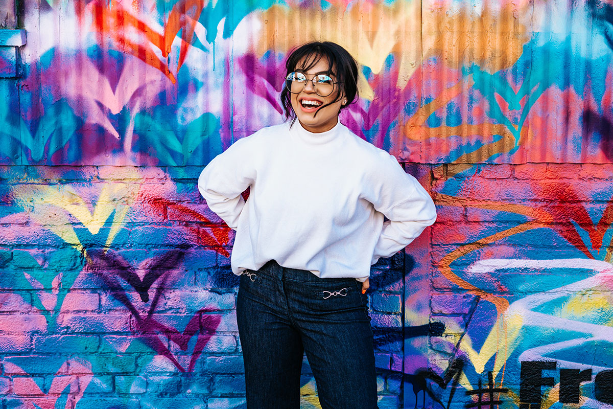 Woman standing in front of a graffiti wall