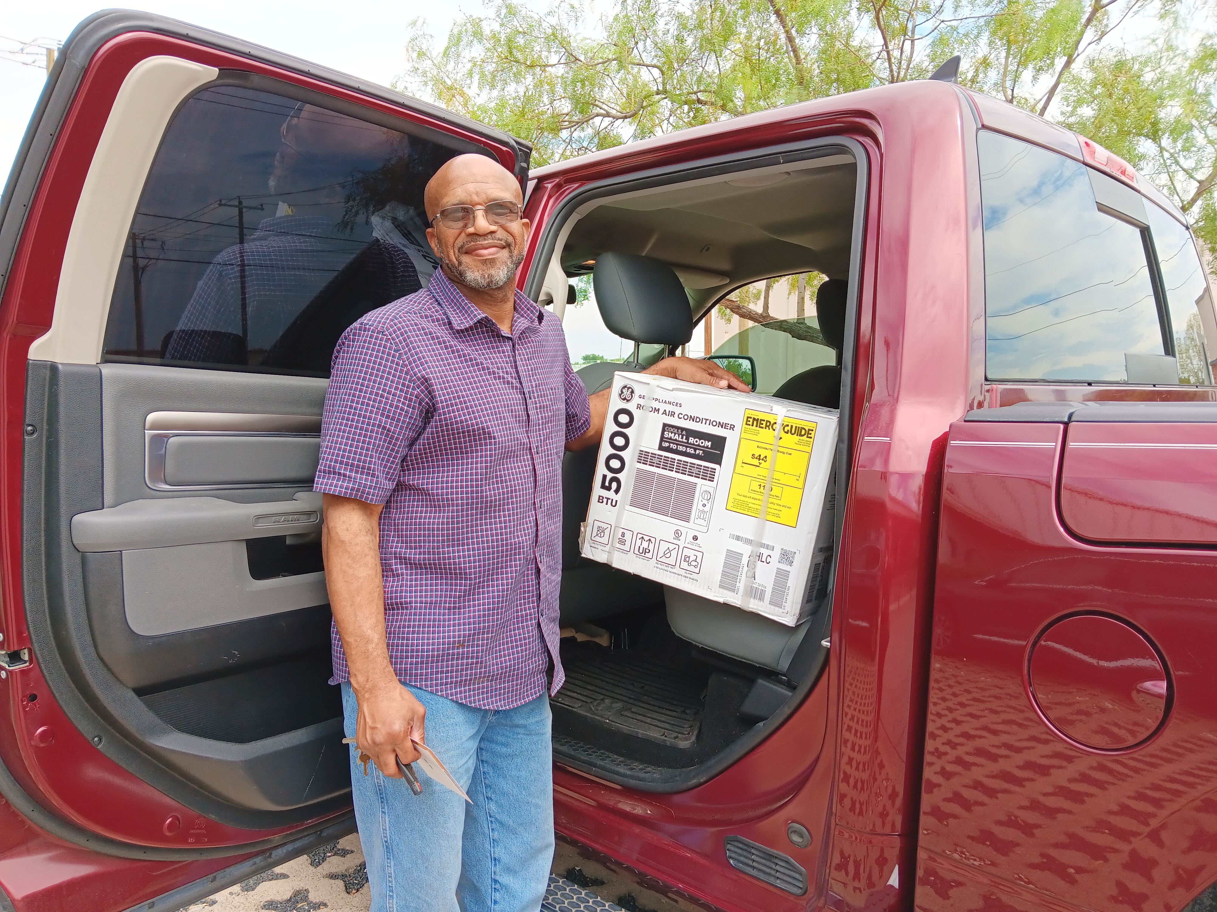 Veteran stands next to the A/C unit sitting in the backseat of his pickup truck outside of United Way of Tarrant County's office.