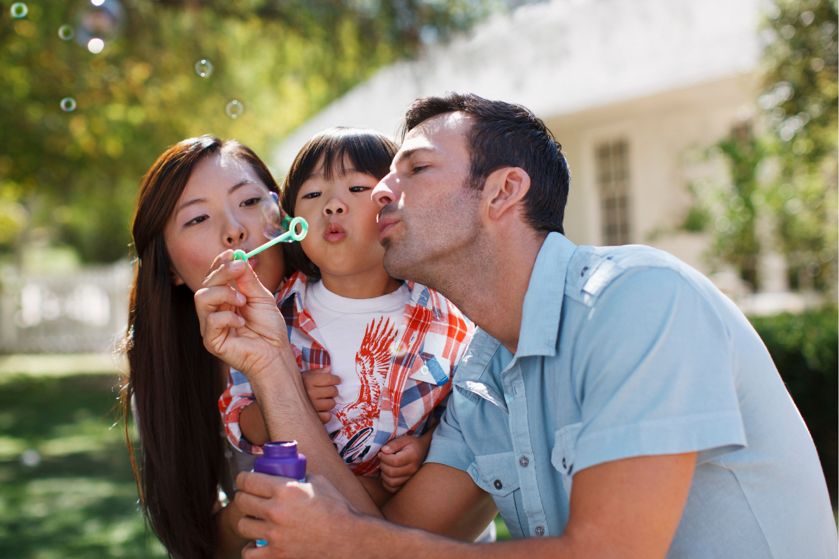 Family blowing bubbles outside