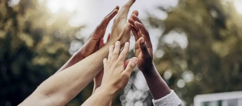People putting their hands together in the air