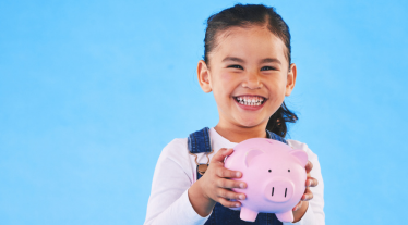 Child holding a piggy bank. 