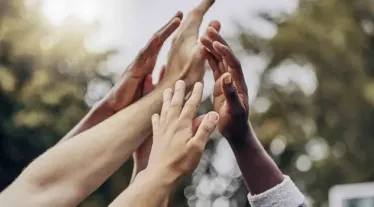 People putting their hands together in the air